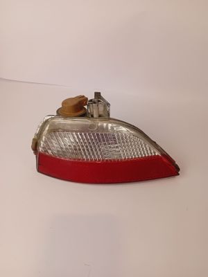un gros plan d'un feu arrière rouge sur une surface blanche