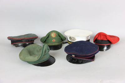 several hats and caps sitting on top of each other on a white surface