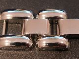 four silver metal knobs sitting on top of a black surface