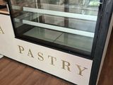 une vitrine à pâtisseries au milieu d'une cuisine