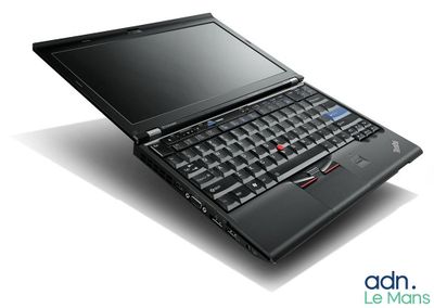 un ordinateur portable noir posé sur une surface blanche