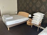 a bed and a chair in a room with a wallpapered wall