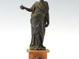 statue en bronze représentant une femme tenant un vase, posée sur un socle en bois