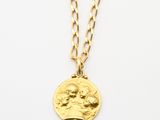 un collier en or avec une pièce de monnaie sur une chaîne