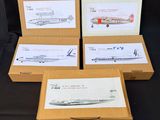 quatre boîtes contenant des maquettes d'avions, posées sur une surface noire