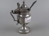 a silver cup with a spoon and spoon rest on top of it