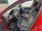 l'intérieur d'une voiture rouge, la portière ouverte et le siège relevé
