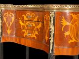 a small chest of drawers that has a design on it