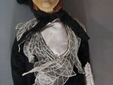 a doll that is wearing a black dress and a white shirt