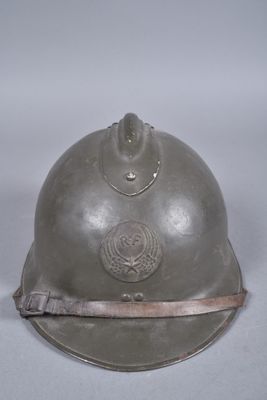 Un vieux casque est posé sur une table devant un fond blanc.