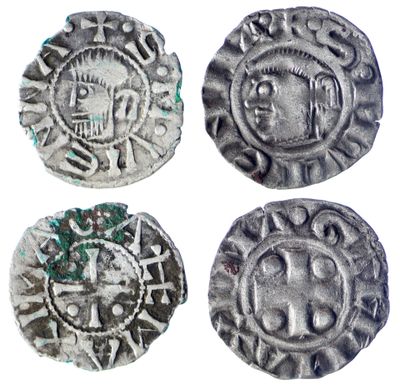 quatre pièces d'argent sur lesquelles sont gravés un crâne et une croix