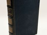 a black book sitting on top of a table next to a white wall