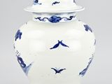 blue and white vase with birds on it on a gray background