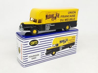 yellow and black toy truck sitting on top of a blue and white box