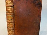 a close up of a brown book on a white surface