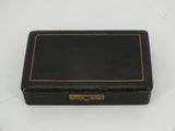 an old black box sitting on top of a white table