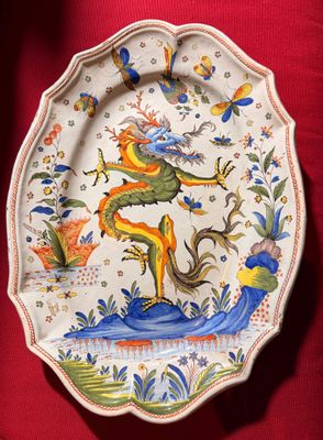 une assiette ornée d'un dragon, posée sur une nappe rouge
