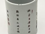 a white cup with asian writing on it on a white surface