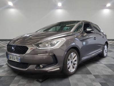 the grey car is parked on a checkered floor in the garage