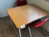 a wooden table and two red chairs in a room