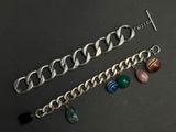 a close up of a chain bracelet with charms on it