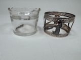 a glass cup and a silver ring on a white table