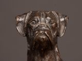 a bronze statue of a dog with a sad look on its face