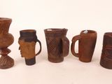 many different types of vases and cups on the table