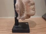a sculpture of a head on a stand on a table