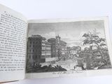 an open book with a picture of a town on it