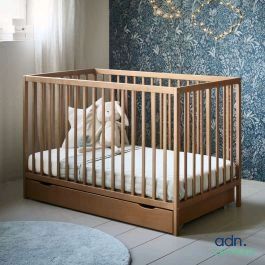 un chien assis dans un lit d'enfant, dans une pièce