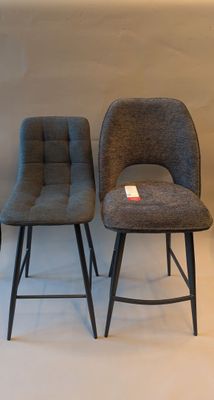 two gray chairs sitting next to each other on a white floor