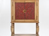 a wooden cabinet with a red and gold design on the door