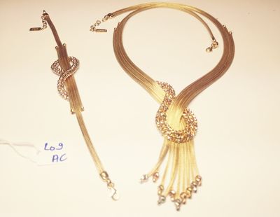 a gold necklace and a gold bracelet on a table