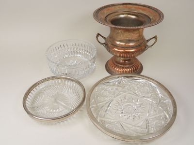 three glass dishes and a silver vase on a table