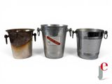 three metal buckets sitting next to each other on a white surface