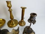 many different types of brass candlesticks on the table
