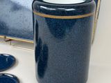 a blue vase with a gold rim next to a mirror