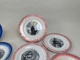 many plates with pictures of people on them on a table