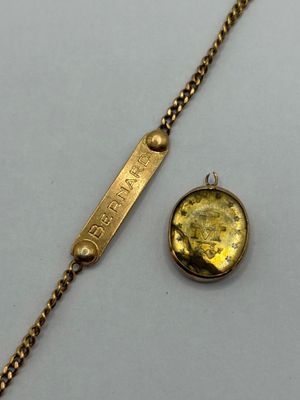 a close up of a gold bracelet with a coin on it