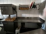 plan de travail en acier inoxydable dans une cuisine professionnelle, avec de la vaisselle et des ustensiles