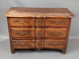 une commode en bois avec des poignées en laiton et des tiroirs