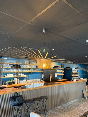 une photo d'un restaurant avec un bar et des chaises