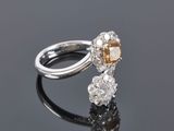 a diamond and white gold ring on a reflective surface