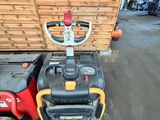 un chariot élévateur rouge et jaune garé devant une caisse en bois
