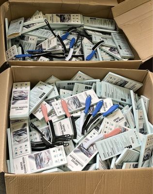 deux boîtes remplies de ciseaux posées l'une sur l'autre