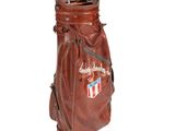 a brown leather bag with golf clubs in it