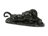 sculpture noire représentant un bélier couché sur une feuille posée sur une surface blanche