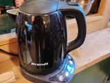 une cafetière noire posée sur une étagère en bois