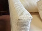 a close up of a white couch with pillows on it